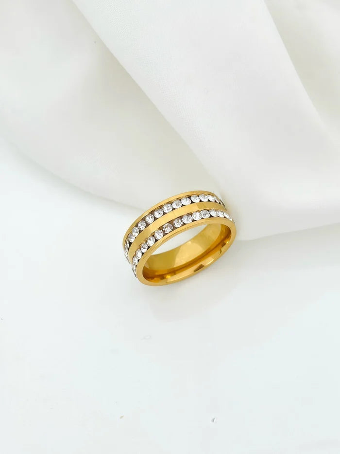 Gold-toned band ring resting on ivory silk